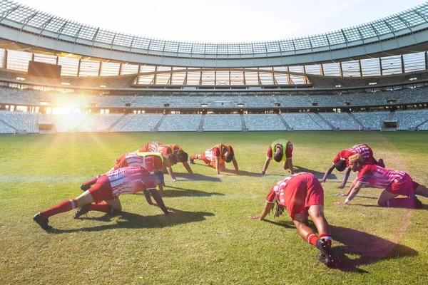 Team of multiracial male players in sports clothing exercising in soccer field. Sport, competitive sport, skill, athlete, teamwork, fitness, stadium.