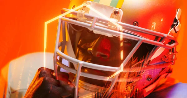 美国足球运动员头戴头盔 看着橙色背景的特写 复制空间 霓虹灯 发光和形状概念 — 图库照片