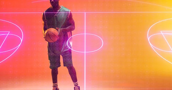 Мидсекция Африканского Американского Игрока Держит Мяч Стоящий Над Освещенной Баскетбольной — стоковое фото