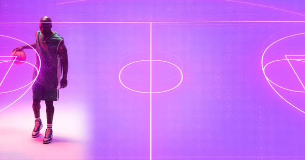 照明付きのコートに立ってボールを持つアフリカ系アメリカ人バスケットボール選手の高角度ビュー コピースペース スポーツ イラスト 形と抽象的な概念 — ストック写真