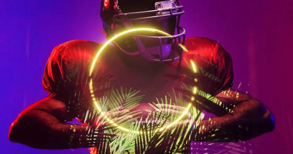 Giocatore Football Americano Indossando Casco Tenendo Palla Cerchio Illuminato Piante — Foto Stock
