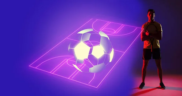 Digital composite image of young caucasian player with illuminated neon soccer field, copy space. Computer graphic, soccer, sport, design, athlete, competitive sport.