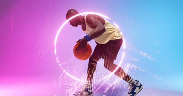 Вид Сбоку Лысого Африканского Игрока Дриблирующего Баскетбол Освещенными Кругами Растениями — стоковое фото