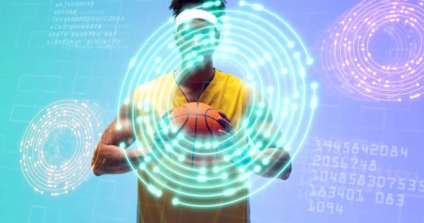 Biraciální Mužský Hráč Drží Basketbal Nad Osvětlenými Kruhy Počítačovým Jazykem — Stock fotografie