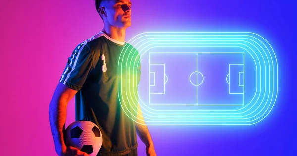 白人年轻球员在蓝粉色背景的霓虹灯足球场旁持球 复制空间 计算机图形 数字合成 运动员 竞技体育 — 图库照片