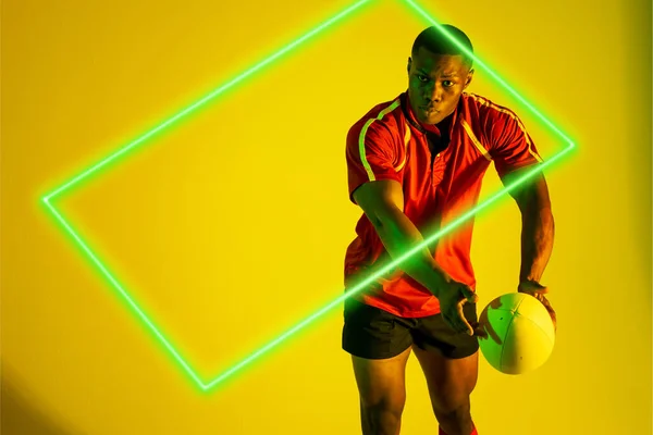 Rechthoek Neon Afrikaanse Amerikaanse Jonge Rugbyspeler Spelen Tegen Gele Achtergrond — Stockfoto