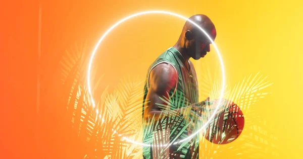 Вид Сбоку Лысого Африканского Баскетболиста Держащего Мяч Светящимся Кругом Растениями — стоковое фото