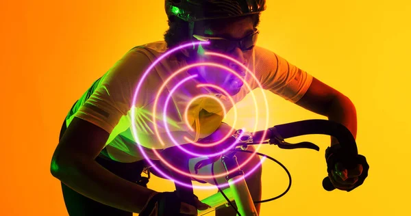 Dwurasowa Rowerzystka Nosząca Okulary Kask Rowerze Nad Oświetlonym Kolistym Wzorem — Zdjęcie stockowe