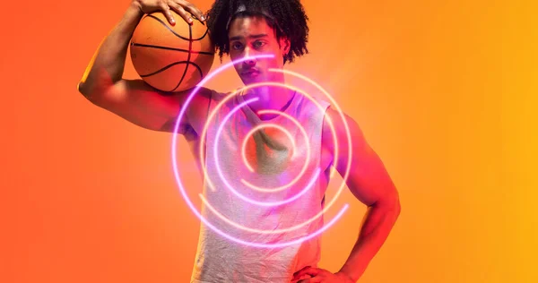 黄色の背景にライトアップされた円形のパターンによってバスケットボールを保持する生物の選手の複合体 コピースペース シリアス スポーツ イラスト 形状と抽象的な概念 — ストック写真