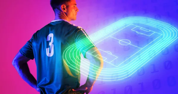 青とピンクの背景の上にネオンサッカーフィールドによって腕Akimboと自信を持って白人選手 コンピュータグラフィックス コピースペース デジタル複合体 サッカー デザイン アスリート 競争力のあるスポーツ — ストック写真
