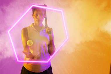 Afrika kökenli Amerikalı kadın oyuncu. Raket ve topla. Altıgen boyayla aydınlatılmış, dumanlı arka planda. Boşluğu kopyala, kompozit, tenis, spor, şekil, rekabet, oyun, eşleşme ve soyut kavram.