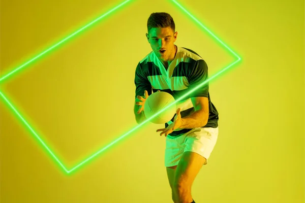 Giocatore Rugby Maschile Caucasico Cattura Palla Rettangolo Illuminato Sfondo Giallo — Foto Stock