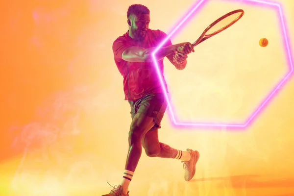Afrykański Amerykański Zawodnik Grający Tenisa Rakietą Piłką Nad Oświetlonym Sześciokątem — Zdjęcie stockowe