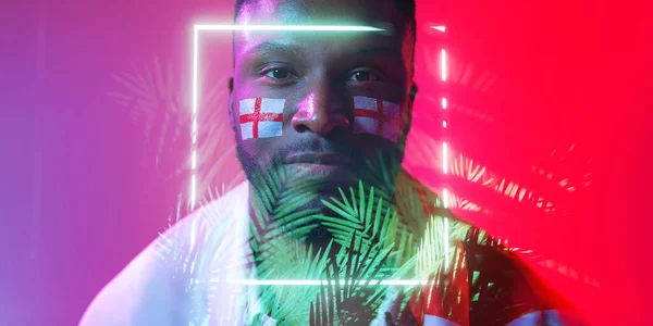 African american male fan with england flag and face paint over illuminated rectangle and plants. Copy space, composite, sport, competition, soccer, support, nature, shape, patriotism, cheering.