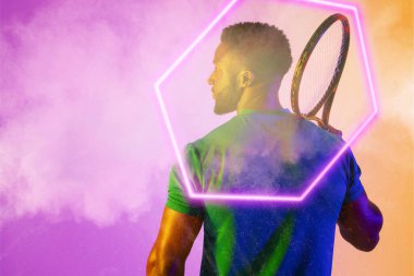 Afro amerikan erkek oyuncunun dumanlı arka planda ışıklı altıgenli raketi. Boşluğu kopyala, kompozit, spor, şekil, tenis, rekabet, oyun, eşleşme ve soyut kavram.