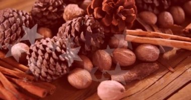 Çam kozalakları ve ahşap yüzeyde tarçın çubukları üzerinde mutlu bayramlar yazılı mesaj pankartı. Noel kutlaması ve yeni yıl kutlaması konsepti