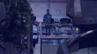 Animation of data processing over man running on treadmill, exercising in gym. Global sports, fitness, computing and data processing concept digitally generated video.