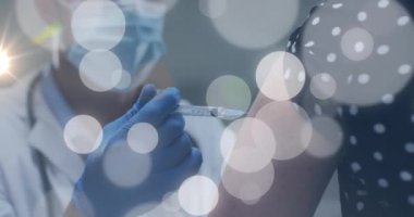 Animation of light spots over diverse doctor and patient vaccinating. Global medicine, healthcare and digital interface concept digitally generated video.