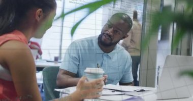 Animation of financial data processing over diverse business people discussing work at office. Global business, finances and digital interface concept digitally generated video.