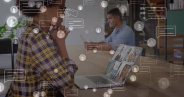 Animation of social media icons with speech bubbles over african american woman using laptop. Global social media, technology and digital interface concept digitally generated video.