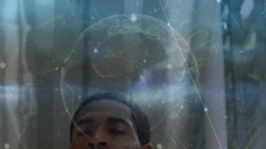 Animation of globe with connections and data processing over african american businessman. Global business, finance, computing and data processing concept digitally generated video.
