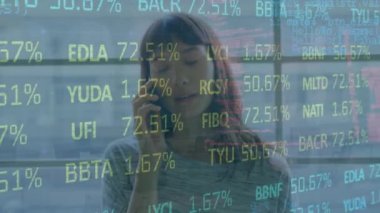 Animation of trading board, computer language over asian woman talking on cellphone in office. Digital composite, multiple exposure, coding, business, stock market and technology concept.