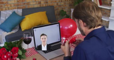Animation of caucasian man using laptop with copy space and caucasian woman. Celebration and party concept digitally generated video.