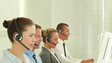 Animation of snowfall over caucasian customer service representatives working on computer in office. Digital composite, multiple exposure, call center, teamwork, abstract and technology concept.