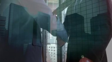 Animation of cityscape over diverse business people working at office. Global business, finances and digital interface concept digitally generated video.