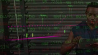 Animation of financial data processing and world map over african american man using tablet. Global technology, finances and digital interface concept digitally generated video.
