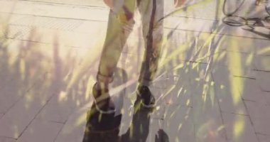 Animation of grass over diverse people riding bike and skateboarding. Global travel, transport and lifestyle concept digitally generated video.