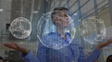 Animation of globes with connections and data processing over diverse business people in office. Global business, finance, computing and data processing concept digitally generated video.