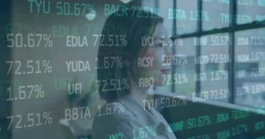 Animation of financial data processing over biracial businesswoman working in office. Global business, finance, computing and data processing concept digitally generated video.