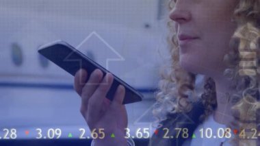 Animation of arrows and data processing over caucasian businesswoman using smartphone. Global business, finances, computing and data processing concept digitally generated video.
