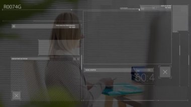 Animation of financial data processing over caucasian businesswoman using laptop in office. Global business, finance, computing and data processing concept digitally generated video.