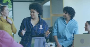 Animation of icons and data processing over diverse business people in office. Global connections, business, finance, computing and data processing concept digitally generated video.