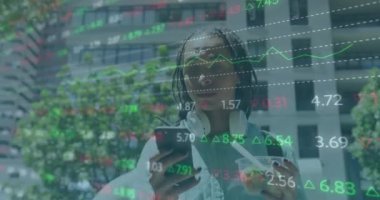 Animation of trading board over african american woman with beverage using smartphone. Digital composite, multiple exposure, stock market, investment, abstract and technology concept.