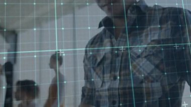 Animation of grid network over asian man using smartphone at office. Computer interface and business technology concept