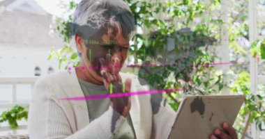 Animation of data processing over african american woman having a video call on digital tablet. Global economy and business technology concept