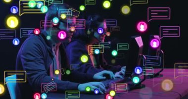 Animation of social media icons and data processing over business people using computers. Global social media, business, finance, computing and data processing concept digitally generated video.