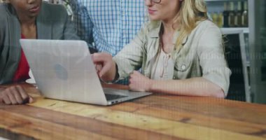 Animation of financial data processing over diverse business people using laptop. Global business, finances, computing and data processing concept digitally generated video.