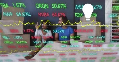 Animation of financial data processing with light bulb icon over diverse couple moving house. Global lifestyle, finances and digital interface concept digitally generated video.