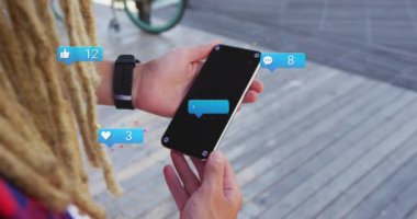Animation of social media icons with numbers over biracial man using smartphone. Global social media, technology and digital interface concept digitally generated video.