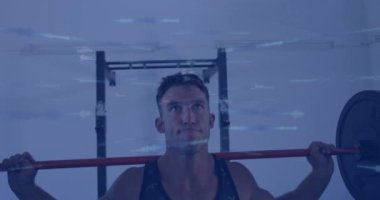 Animation of data processing over man lifting weights, exercising in gym. Global sports, fitness, computing and data processing concept digitally generated video.