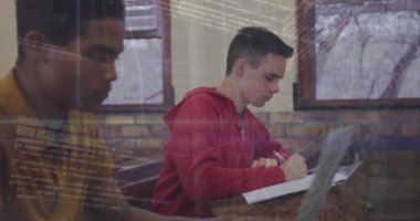 Animation of binary codes, trading board over diverse male students writing in book at classroom. Digital composite, multiple exposure, education, school, coding, machine learning and technology.