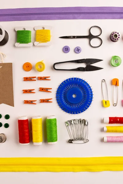 Image of sewing materials with scissors, buttons and threads on cream background. Arts and crafts concept.