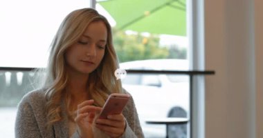 Animation of social media icons over caucasian woman using smartphone. Global social media, connections and data processing concept digitally generated video.