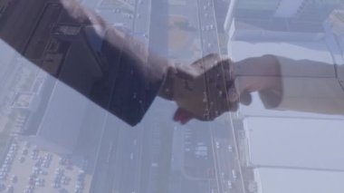 Animation of businessman handshake over cityscape. Global finance, business and data processing concept digitally generated video.