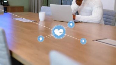 Animation of network of connection with icons over african american businessman using smartphone. Global business, computing, connections and data processing concept digitally generated video.