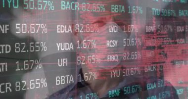 Animation of financial data processing over man wearing face mask. Global covid 19, computing, finance, business and data processing concept digitally generated video.